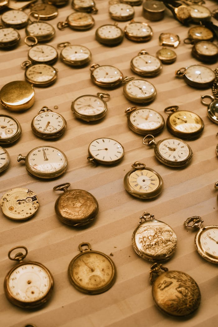 team-01 A collection of vintage pocket watches displayed on a striped surface, showcasing timeless elegance.