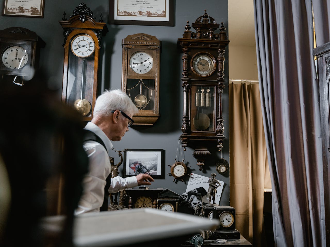 services-02 Watchmaker in vintage repair shop surrounded by antique wall clocks and intricate timepieces.