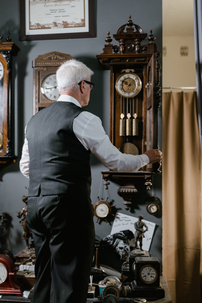 services-03 Senior adjusting vintage clocks in antique shop, showcasing timeless craftsmanship.