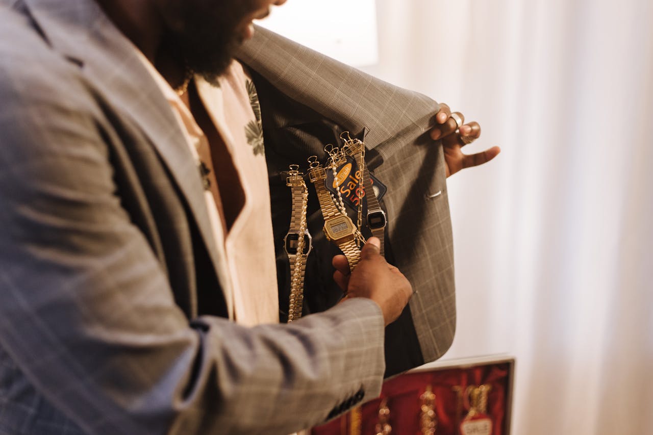 services-01 A man reveals multiple watches inside his suit jacket, showcasing a variety of styles.